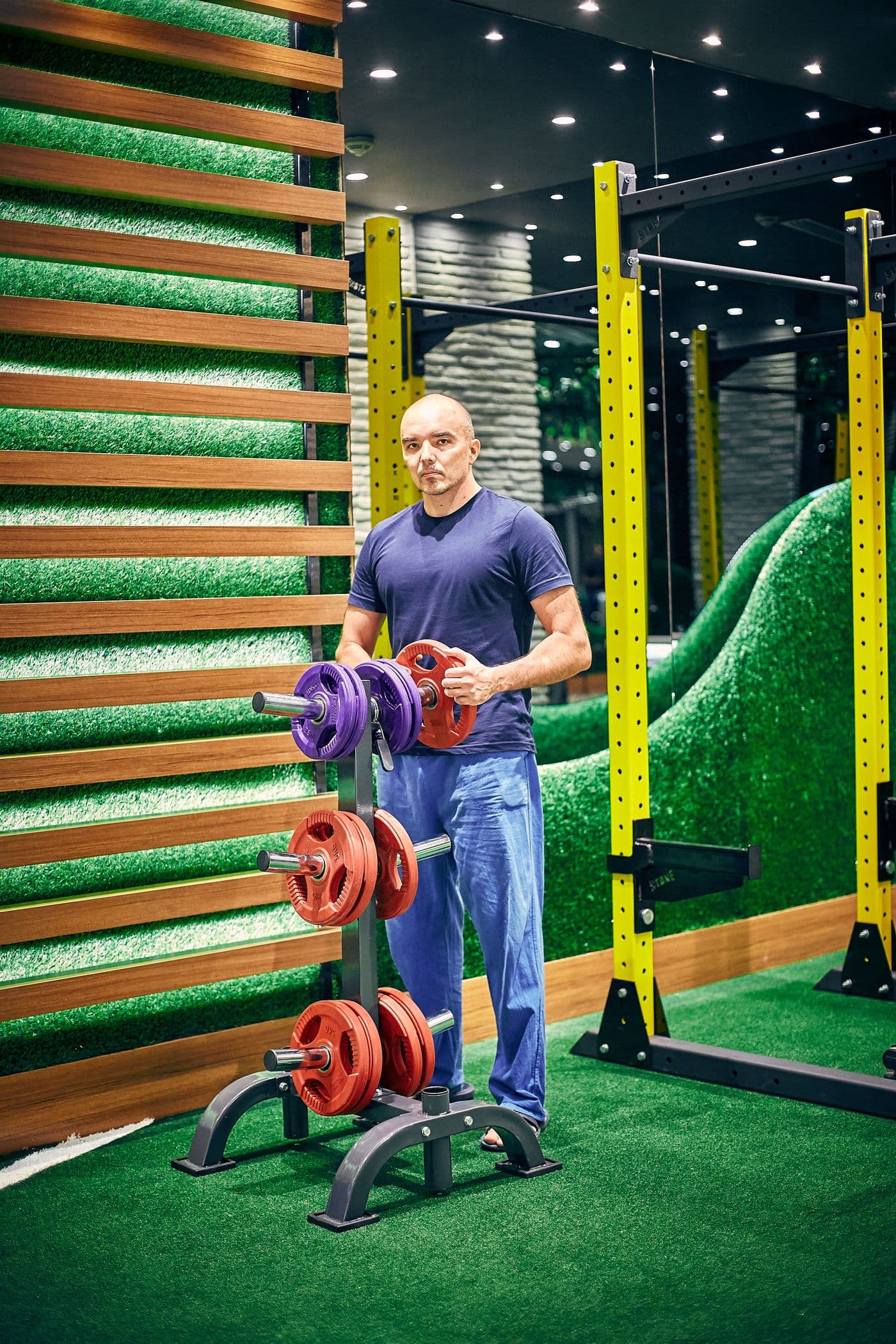 A studio owner racking weights on the floor