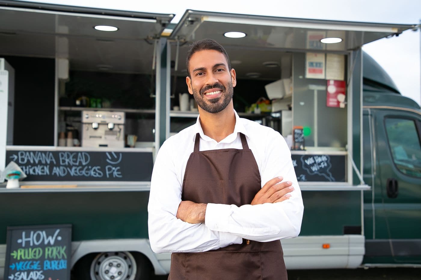 An owner standing at the window of his food truck